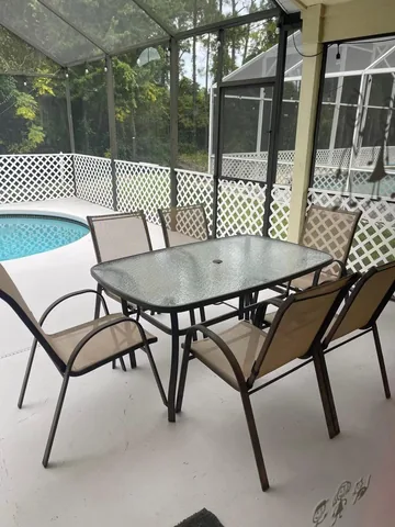 Screened pool and covered lanai with patio table and chairs